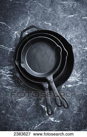 Cast iron pans on a marble surface View Large Photo Image Stock Photo - Cast iron pans on a marble surface. Fotosearch