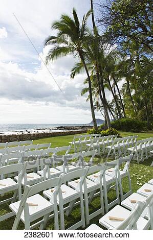 Chairs set up for an outdoor wedding at the water's edge with a view of the ocean; Honolulu, Oahu, Hawaii, United States of America View Large Photo Image Stock Image - Chairs set up for an outdoor wedding at the water's edge with a view of the ocean; Honolulu, Oahu, Hawaii, United States of America. Fotosearch