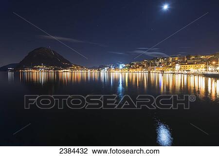 City lights illuminated on the tranquil Lake Lugano; Lugano, Ticino, Switzerland View Large Photo Image Stock Image - City lights illuminated on the tranquil Lake Lugano; Lugano, Ticino, Switzerland. Fotosearch