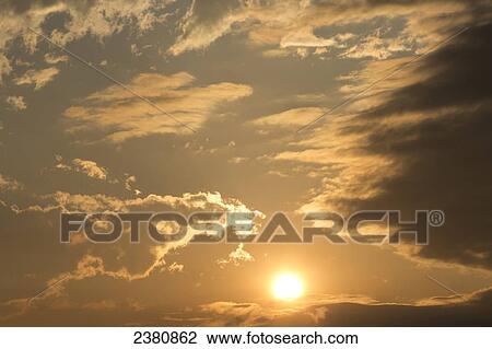 Stock Image - Clouds glowing from the sunlight; Whitehorse, Yukon, Canada. Fotosearch