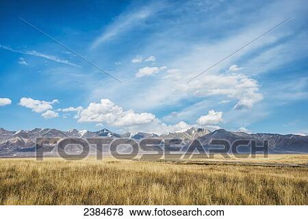 Stock Photo - Clouds in a blue sky over the flat Tibetan plains and mountains; Tibet, China. Fotosearch
