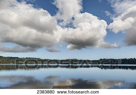 Stock Image - Clouds reflected into Lake Ianthe; South Island, New Zealand. Fotosearch