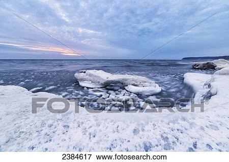 Stock Photo - Cool blue ice and clouds on softer ice on the shores of Lake Michigan; Wisconsin, United States of America. Fotosearch