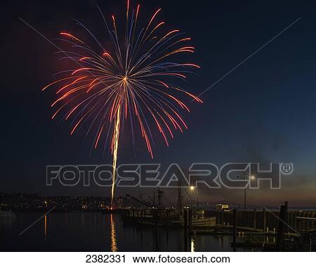 Stock Image - Fireworks display above the water; Astoria, Oregon, United States of America. Fotosearch