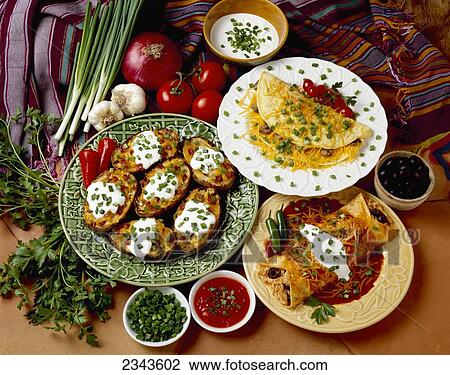 Stock Image - Food - Prepared dishes garnished with chopped green onions (scallions), including Chicken and Cheese Enchilada, Cheese and Mushroom Omelet, and Twice-Baked Potatoes with Bacon.. Fotosearch
