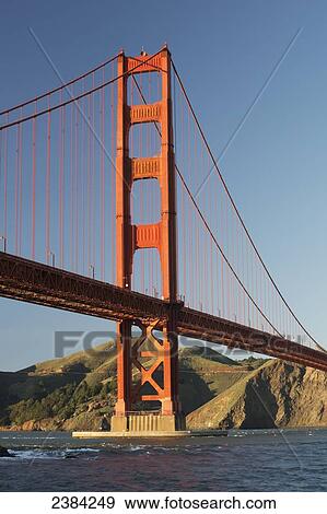 Stock Photo - Golden Gate Bridge from Fort Point at the entrance to San Francisco Bay, Marin Headlands visible in background; San Francisco, California, United States of America. Fotosearch