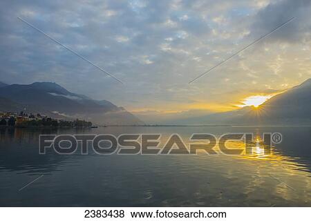 Golden sunlight reflected on tranquil Lake Maggiore; Locarno, Ticino, Switzerland View Large Photo Image Stock Photo - Golden sunlight reflected on tranquil Lake Maggiore; Locarno, Ticino, Switzerland. Fotosearch