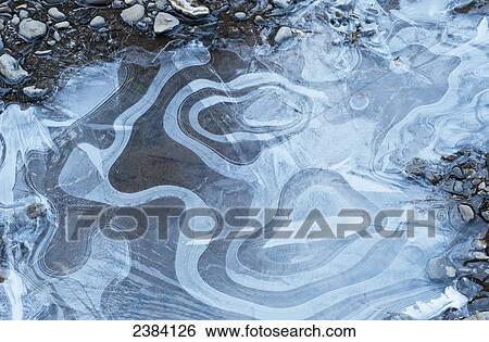 Stock Photograph - Ice patterns are found along Youngs River; Olney, Oregon, United States of America. Fotosearch