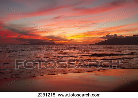 Stock Photo - Incredibly brilliant Wailea sunset as viewed from Keawekapu Beach; Maui, Hawaii, United States of America. Fotosearch