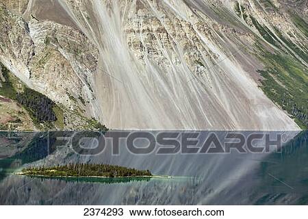 Island in mountain lake with cliff face in background and reflecting in lake; Yukon, Canada View Large Photo Image Stock Image - Island in mountain lake with cliff face in background and reflecting in lake; Yukon, Canada. Fotosearch