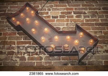 Lighted metal arrow sign on brick wall; Starkville, Mississippi, United States of America View Large Photo Image Stock Photography - Lighted metal arrow sign on brick wall; Starkville, Mississippi, United States of America. Fotosearch