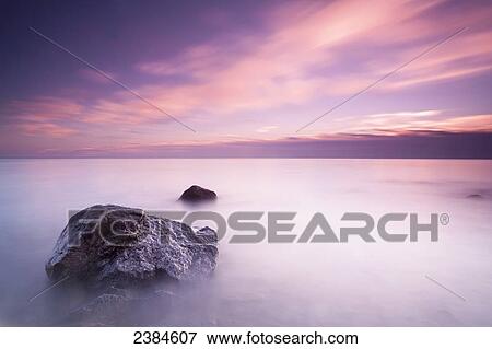 Stock Photo - Long exposure makes the water of Lake Michigan into mist on a cloudy morning; Wisconsin, United States of America. Fotosearch