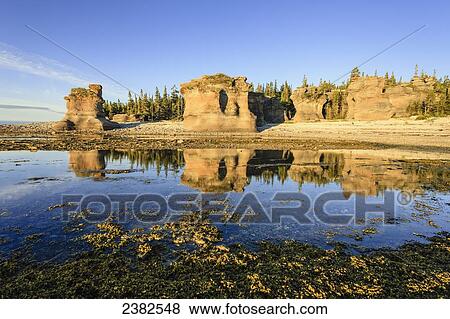 Stock Photo - Monolith at sunrise, Anse des Bonnes Femmes at Ile Niapiskau, Mingan Archipelago National Park Reserve of Canada, Cote-Nord, Duplessis region; Quebec, Canada. Fotosearch