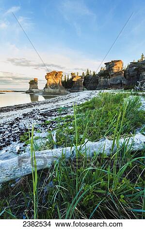 Picture - Monolith at sunset, Anse des Bonnes Femmes at Ile Niapiskau, Mingan Archipelago National Park Reserve of Canada, Cote-Nord, Duplessis region; Quebec, Canada. Fotosearch