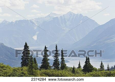 Picture - Mountain vista with river valley, glaciers, blue sky and clouds; Yukon, Canada. Fotosearch