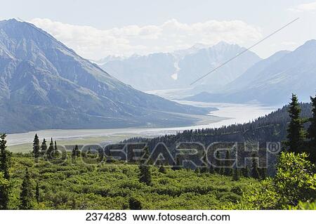 Mountain vista with river valley, glaciers, blue sky and clouds; Yukon, Canada View Large Photo Image Stock Image - Mountain vista with river valley, glaciers, blue sky and clouds; Yukon, Canada. Fotosearch