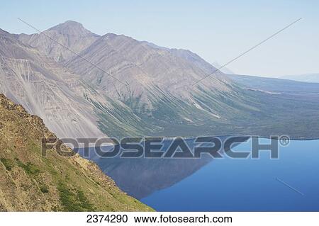 Stock Image - Mountains reflected in a tranquil lake, Haines Junction; Yukon, Canada. Fotosearch
