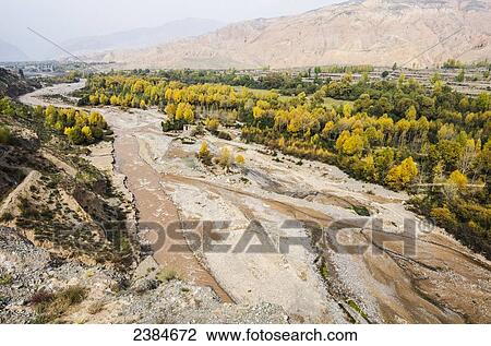 Muddy river, autumn coloured trees and distant red mountains near Yinzha Kimura city; China View Large Photo Image Stock Image - Muddy river, autumn coloured trees and distant red mountains near Yinzha Kimura city; China. Fotosearch