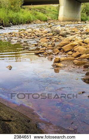 Oil is spilled on the river and rocks from the highway nearby; Fort McMurray, Alberta, Canada View Large Photo Image Stock Image - Oil is spilled on the river and rocks from the highway nearby; Fort McMurray, Alberta, Canada. Fotosearch