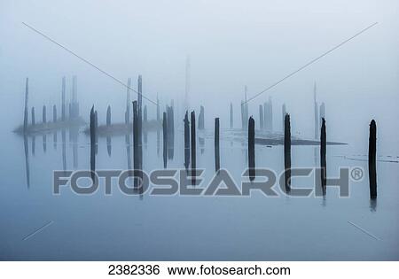 Stock Photograph - Old pilings disappear into the mist; Astoria, Oregon, United States of America. Fotosearch