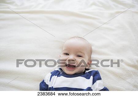 Picture - Portrait of a baby on a white sheet; Victoria, British Columbia, Canada. Fotosearch