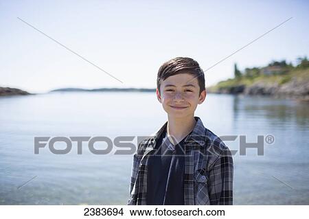 Picture - Portrait of a boy with the water and coastline in the background; Victoria, British Columbia, Canada. Fotosearch