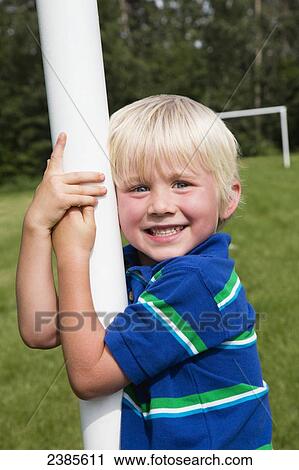 Portrait of a young boy with blond hair hanging onto a soccer goalpost in a park; Stony Plain, Alberta, Canada View Large Photo Image Stock Image - Portrait of a young boy with blond hair hanging onto a soccer goalpost in a park; Stony Plain, Alberta, Canada. Fotosearch