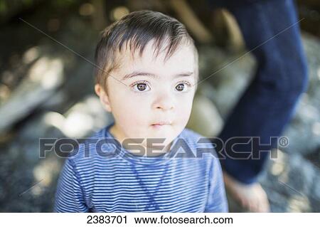 Stock Image - Portrait of a young boy with Down Syndrome; Victoria, British Columbia, Canada. Fotosearch
