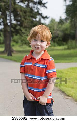 Stock Image - Portrait of a young boy with red hair; Stony Plain, Alberta, Canada. Fotosearch