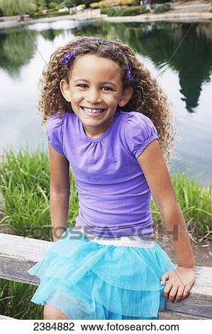 Portrait of a young girl sitting on a wooden fence; Menlo Park, California, United States of America View Large Photo Image Stock Image - Portrait of a young girl sitting on a wooden fence; Menlo Park, California, United States of America. Fotosearch