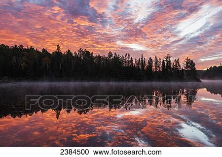 Red clouds light the sky and water of Costello Lake, Algonquin Park; Ontario, Canada View Large Photo Image Stock Image - Red clouds light the sky and water of Costello Lake, Algonquin Park; Ontario, Canada. Fotosearch