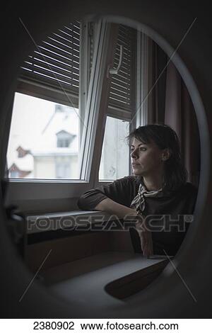 Reflection in a mirror of a woman sitting and looking out the window; Zurich, Switzerland View Large Photo Image Stock Image - Reflection in a mirror of a woman sitting and looking out the window; Zurich, Switzerland. Fotosearch
