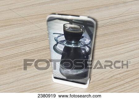 Reflection of a cup of coffee in the back of a cell phone; Locarno, Ticino, Switzerland View Large Photo Image Stock Photo - Reflection of a cup of coffee in the back of a cell phone; Locarno, Ticino, Switzerland. Fotosearch