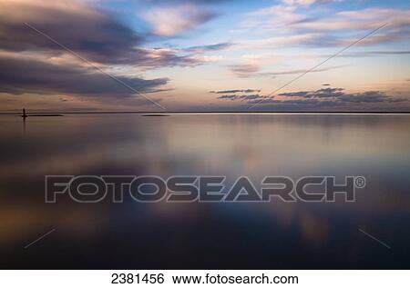 Stock Photograph - Reflections of clouds at dusk on the beach; Wells-next-the-Sea, Norfolk, England. Fotosearch