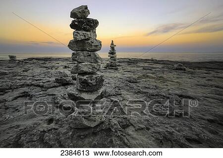 Rock sculptures dot the shoreline as the sun dips below the horizon in Cave Point, Sturgeon Bay; Wisconsin, United States of America View Large Photo Image Stock Image - Rock sculptures dot the shoreline as the sun dips below the horizon in Cave Point, Sturgeon Bay; Wisconsin, United States of America. Fotosearch