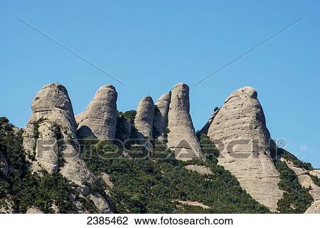 Stock Image - Rugged mountain peaks against a blue sky; Montserrat, Catalonia, Spain. Fotosearch