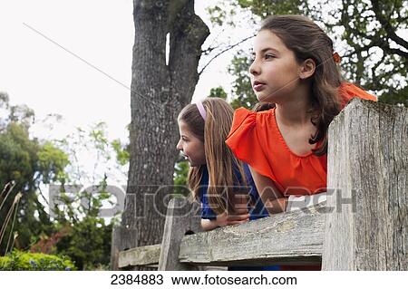 Stock Image - Sisters playing beside each other in a park; Menlo Park, California, United States of America. Fotosearch