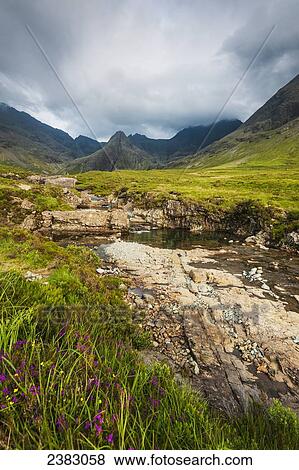 Stock Photo - Small river in Coire na Creiche (The Fairy Pools) near Glen Brittle with the hills of the Black Cuillin in the distance; Isle of Skye, Scotland. Fotosearch
