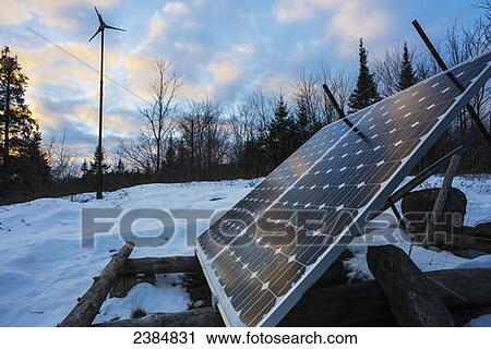 Stock Image - Solar panel and wind turbine in winter; Ontario, Canada. Fotosearch