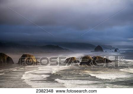 Stock Photo - Sunlight and mist create coastal moods; Cannon Beach, Oregon, United States of America. Fotosearch
