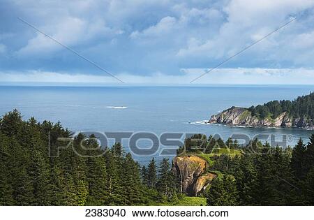 Stock Image - Sunlight shines on Cape Falcon; Manzanita, Oregon, United States of America. Fotosearch