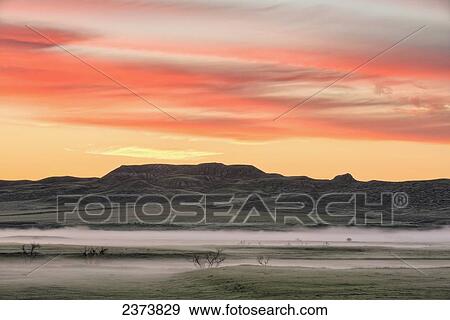 Stock Photo - Sunrise over 70 Mile Butte, Grasslands National Park; Saskatchewan, Canada. Fotosearch