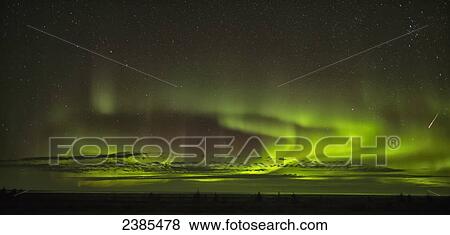 Stock Photo - The aurora borealis and a shooting star above Hudson Bay; Manitoba, Canada. Fotosearch