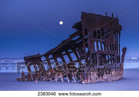 The moon sets over the wreck of the Peter Iredale; Oregon, United States of America View Large Photo Image Stock Photo - The moon sets over the wreck of the Peter Iredale; Oregon, United States of America. Fotosearch