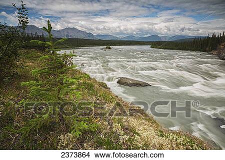 The South Nahanni river flows through 'The Sluice Box' above Virginia Falls, Nahanni National Park Reserve; Northwest Territories, Canada View Large Photo Image Picture - The South Nahanni river flows through 'The Sluice Box' above Virginia Falls, Nahanni National Park Reserve; Northwest Territories, Canada. Fotosearch