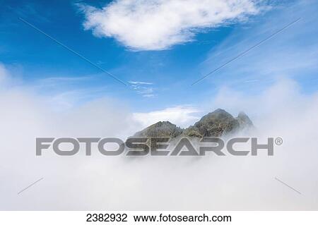 Stock Image - The top of Sgurr Alasdair emerging above clouds in the Black Cuillin; Isle of Skye, Scotland. Fotosearch