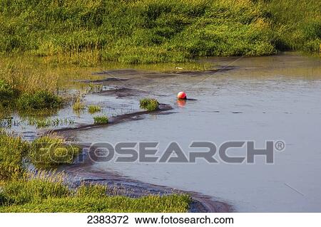 Stock Image - The view of a tailings pond at an oil sands mine site in Northern Alberta; Fort McMurray, Alberta, Canada. Fotosearch