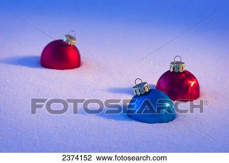 Stock Image - Three Christmas ornaments in the snow; St. Albert, Alberta, Canada. Fotosearch