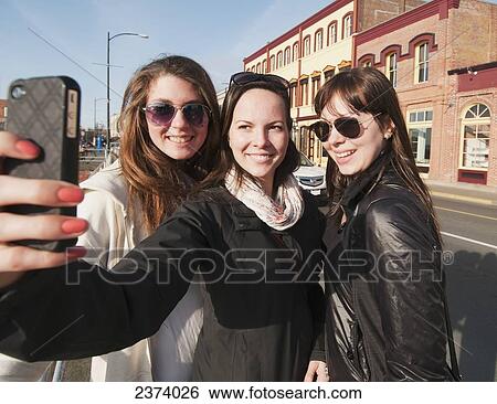 Three young women smile for the camera as they enjoy sightseeing in downtown Victoria; Victoria, British Columbia, Canada View Large Photo Image Stock Photograph - Three young women smile for the camera as they enjoy sightseeing in downtown Victoria; Victoria, British Columbia, Canada. Fotosearch