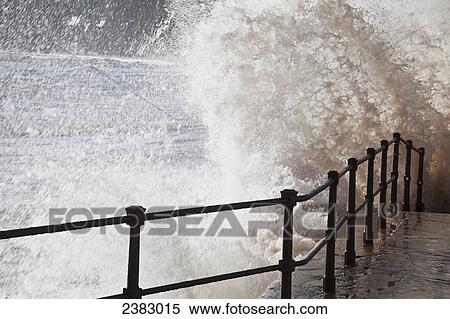 Stock Photography - Waves splashing and crashing into railing and stairs in Jacob's Ladder Bay; Sidmouth, South Devon, England. Fotosearch